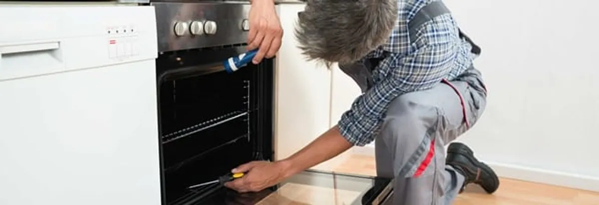 Oven repair technician inspecting and servicing an electric oven in Stamford, CT