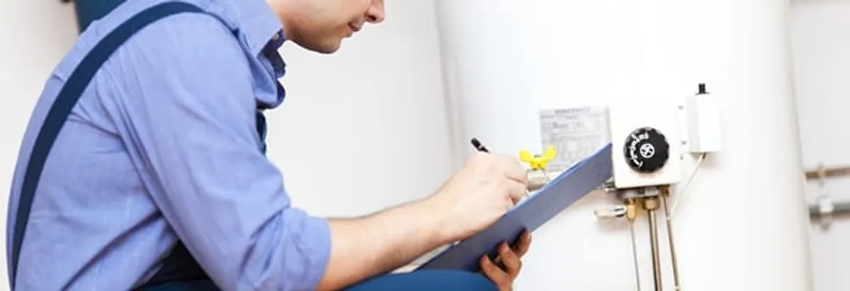 Water heater repair technician inspecting the unit and recording service notes in Stamford, CT